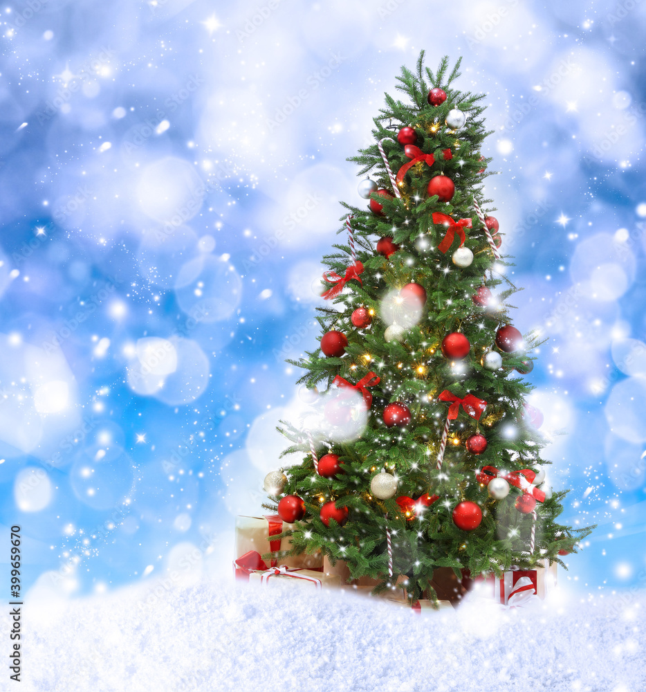 Beautiful decorated Christmas tree and snow on blue background. Bokeh effect