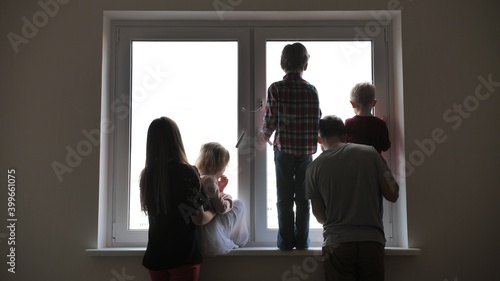 Silhouette of a large family on the background of a window in a new apartment. Quarantine concept.