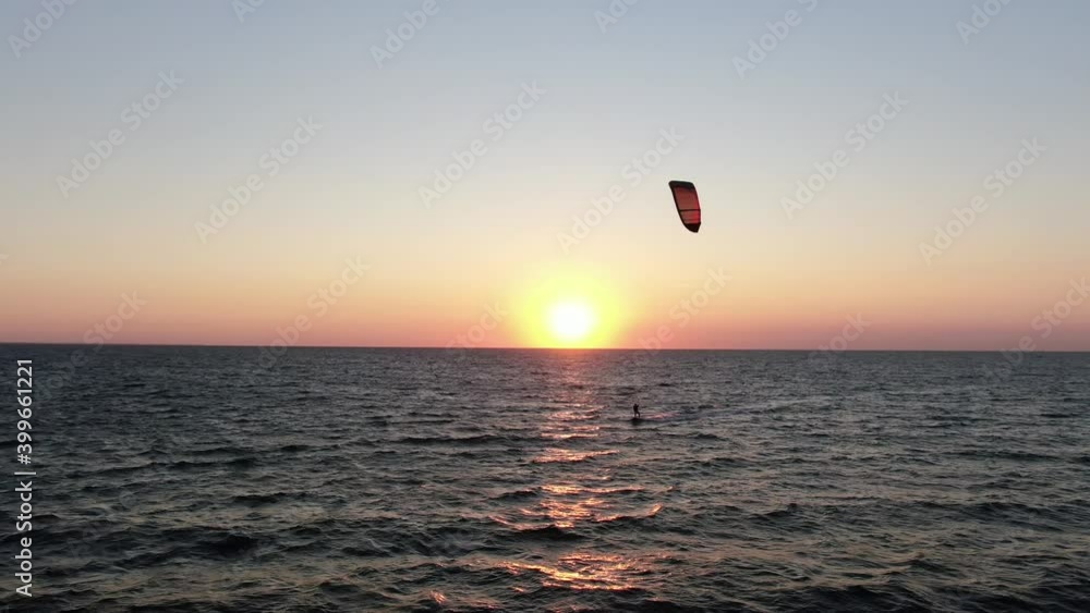 Gorgeous sunset on the horizon and a person kitesurfing in the sea, 4k Gorgeous sunset on the horizon and a person kitesurfing in the sea, 4k