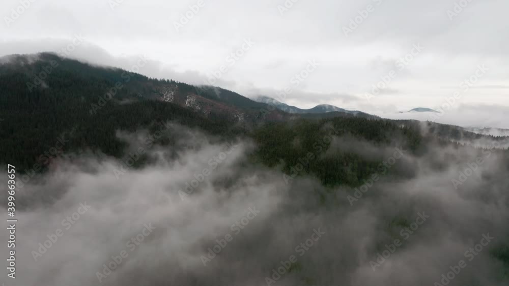 Aerial view. Mysterious mountain landscape on a cloudy autumn day. Foggy forest in the highlands. Natural background. Carpathian mountains. Cloudy gray winter landscape Aerial view. Mysterious mountain landscape on a cloudy autumn day. Foggy forest in the highlands. Natural background. Carpathian mountains. Cloudy gray winter landscape