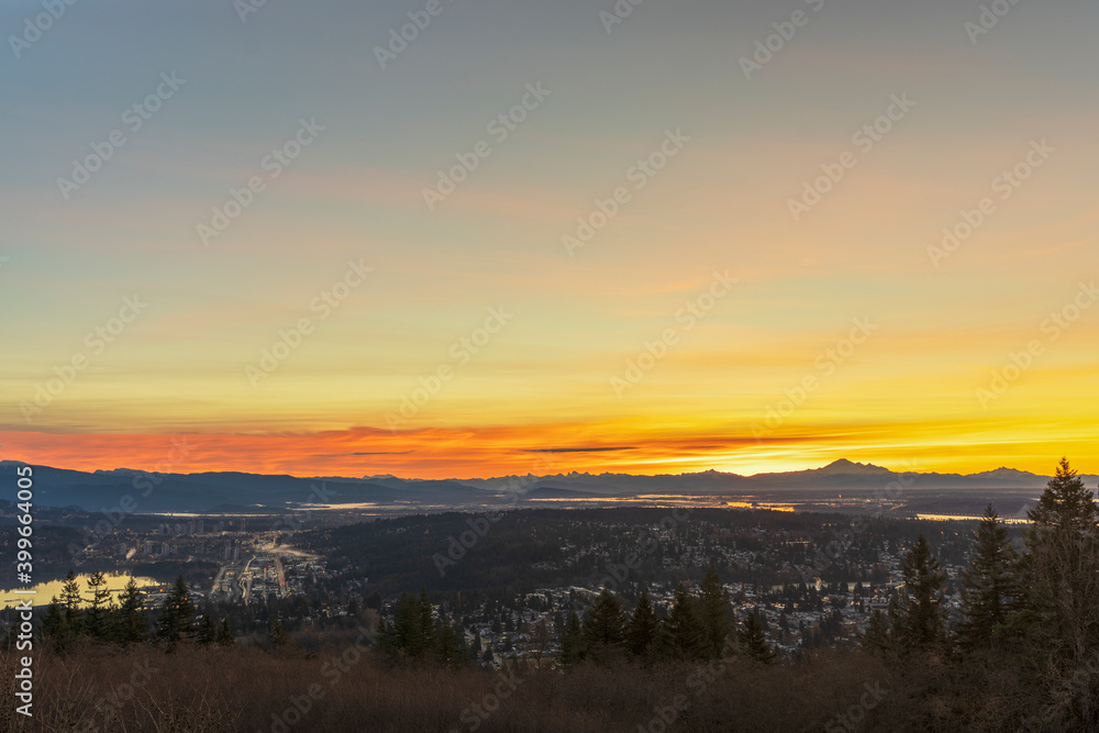 panoramic golden-orange sunrise over BC valley, mountains and water