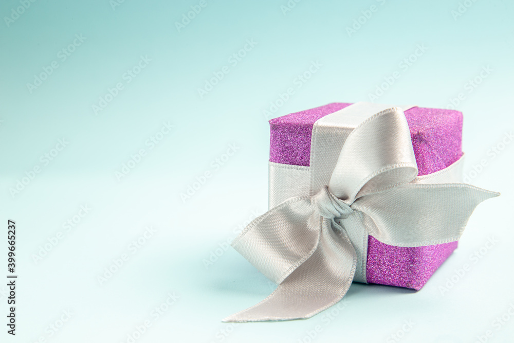 front view cute little present tied with bow on blue background xmas gift new year photo color