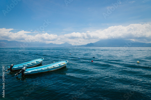 Two blue boats on lake Atitlan with view on volcanoe in Santa Cruz la Laguna, Guatemala © Loes Kieboom