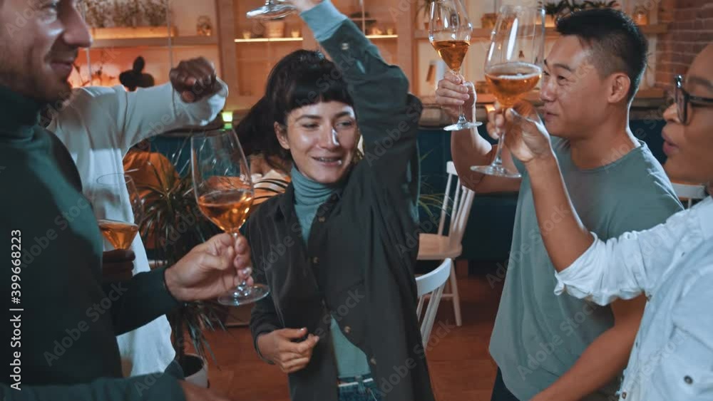 Multi-race happy company young attractive friends gathering in cafeteria dancing into music celebrating party holidays drinking wine together. Multi-race happy company young attractive friends gathering in cafeteria dancing into music celebrating party holidays drinking wine together.
