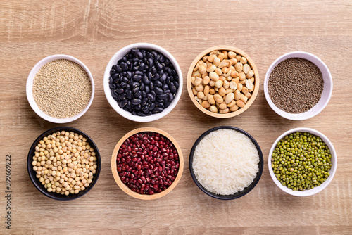 Various cereal grain in a bowl on wooden background  quinoa seeds  black kidney bean  peanut  perilla seeds  soybean  azuki beans  rice grain and mung beans 