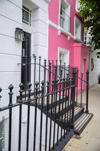 White and pink British houses with handrails outside the door