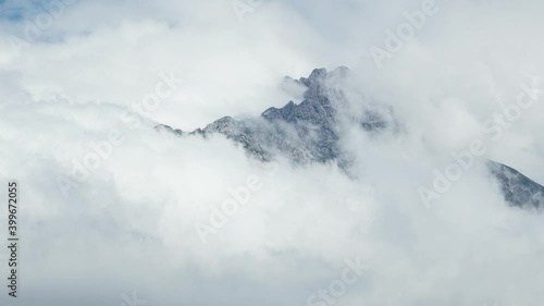 Time Lapse of Steep Mountain Top Surrounded by Grey Clouds in the Sky photo