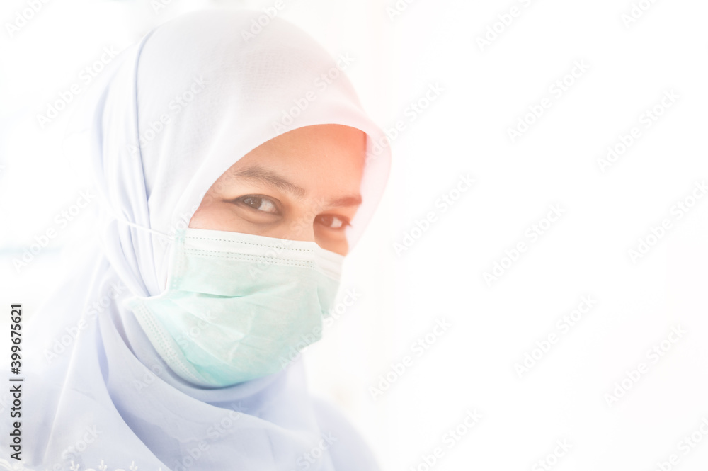 Closeup Asian Muslim female doctor wearing a mask and protective clothing to combat COVID-19 (coronavirus) outbreak of the coronavirus or COVID-19 Closeup Asian Muslim female doctor wearing a mask and protective clothing to combat COVID-19 (coronavirus) outbreak of the coronavirus or COVID-19