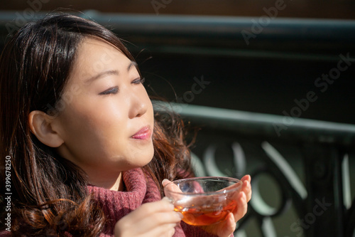 オープンカフェで紅茶を飲む女性