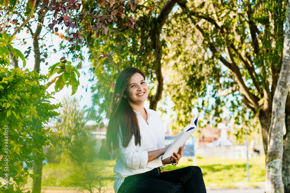 Woman reading a book in a bench of the park. Woman reading a book in a bench of the park.