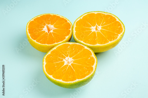 front view fresh tangerine slices on light-blue background photo color orange citrus fruit