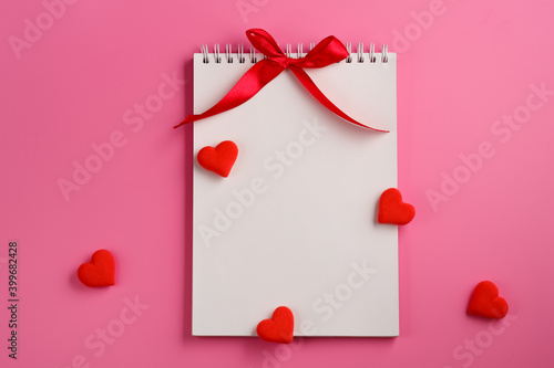 Open blank notebook, red heart on pink background. Valentine's Day and romantic holiday concept. Love message. Top view, flat lay