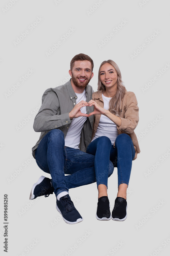 Couple Sitting on Floor Showing Heart Sign. Couple Showing Love Sign. Relationship, Family, Lovers, Friends Concept Couple Sitting on Floor Showing Heart Sign. Couple Showing Love Sign. Relationship, Family, Lovers, Friends Concept