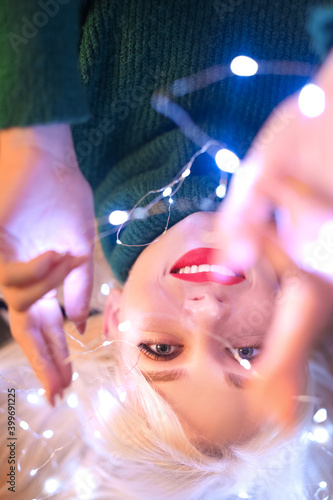 Beautiful woman with Christmas lights, closeup
