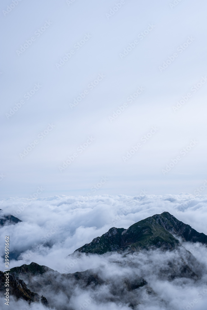 Dramatic view of Kiso Mountains engulfed in a sea of clouds in early autumn at Senjojiki Cirque in Nagano Prefecture, Japan.