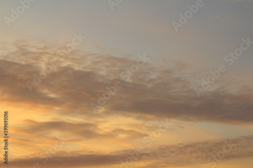 Sun below the horizon and clouds in the fiery dramatic orange sky at sunset or dawn backlit by the sun. Place for text and design