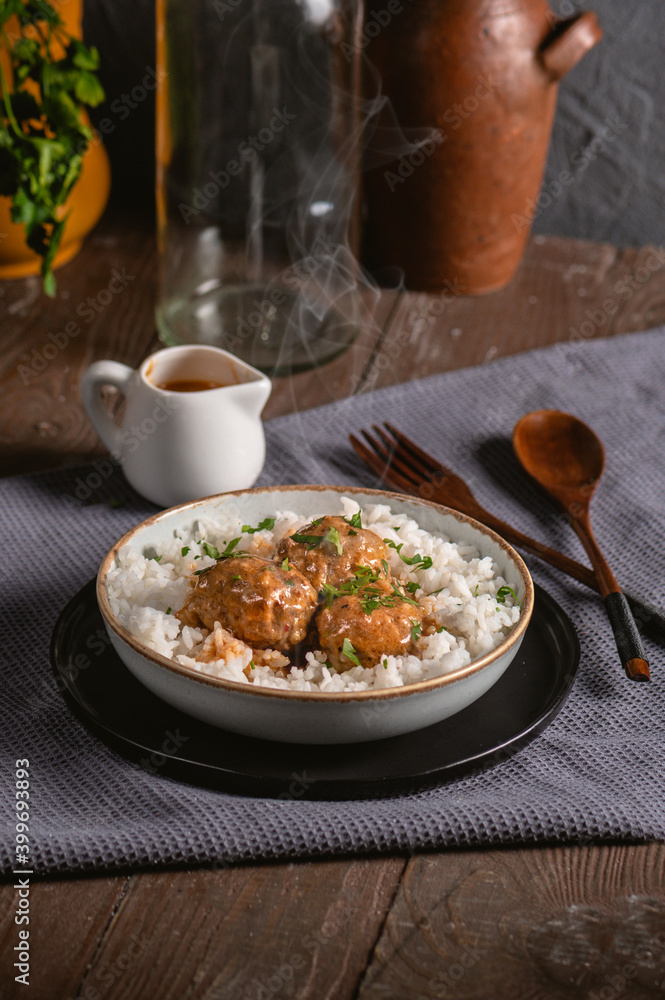 Meatballs with rice on rustic background