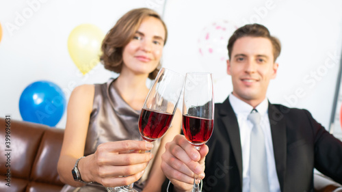 Caucasian couple friends smile and cheers glass of red wine beverage for celebration moment in seasonal such as Valentine’s Day, Happy Anniversary, Christmas party and New Year holiday together