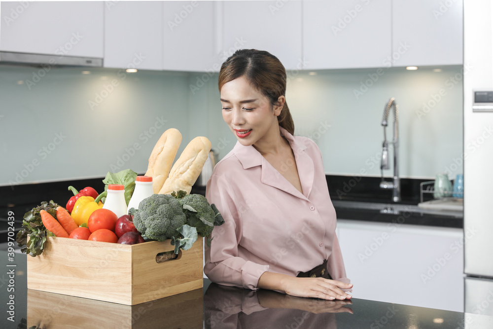 Grocery store smart food delivery serviceman in red uniform handing fresh food to the recipient and young woman customer receiving an order from courier at home, express delivery, food delivery. Grocery store smart food delivery serviceman in red uniform handing fresh food to the recipient and young woman customer receiving an order from courier at home, express delivery, food delivery.