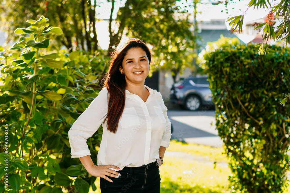 Woman standing and posing with a white wall and plants. Woman standing and posing with a white wall and plants.