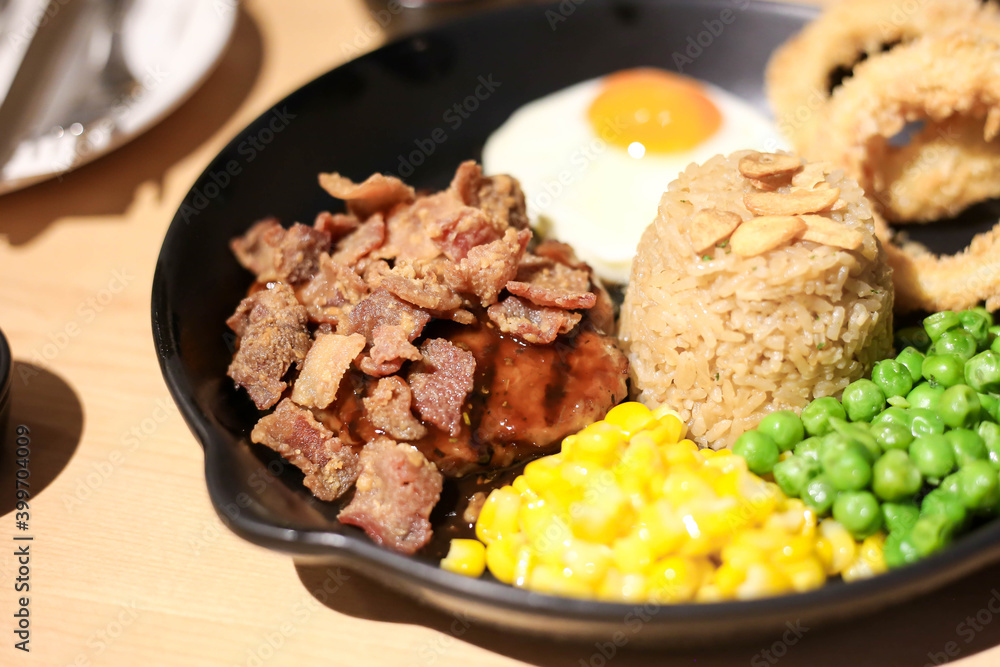 Griled chicken breast steak with rice and onions,corns,Green peas vegetable,soft focus Griled chicken breast steak with rice and onions,corns,Green peas vegetable,soft focus