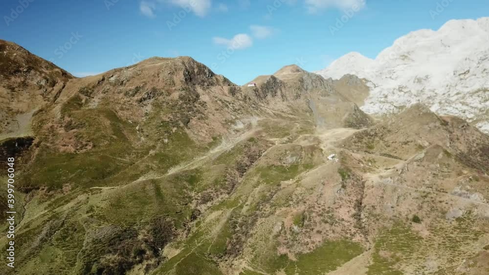 A panoramic drone shot of the Carnic mountain chain in Austrian Alps. Highest parts of the mountains are baren and stony, lower part are overgrown with moss. Lush green valley. Serenity
A panoramic drone shot of the Carnic mountain chain in Austrian Alps. Highest parts of the mountains are baren and stony, lower part are overgrown with moss. Lush green valley. Serenity