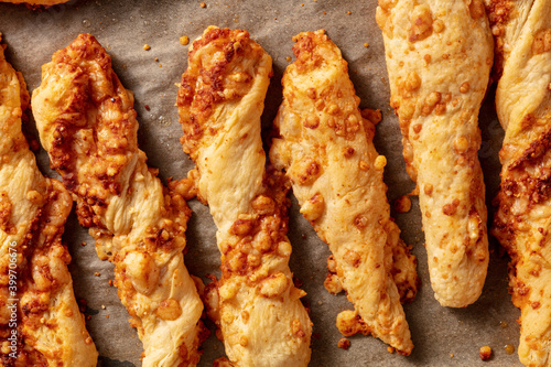 Obraz na plátně Homemade cheese straws on a baking tray, shot from the top