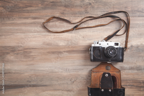 Old retro camera on wooden background.
