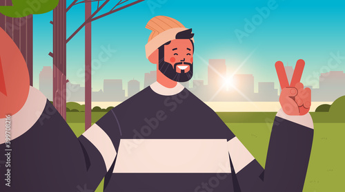 happy man taking selfie on smartphone camera guy making self photo in urban park cityscape background horizontal portrait vector illustration