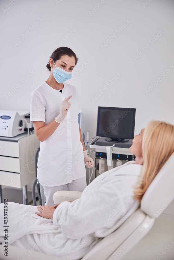 Elegant professional doctor talking with patient in beauty spa center Elegant professional doctor talking with patient in beauty spa center