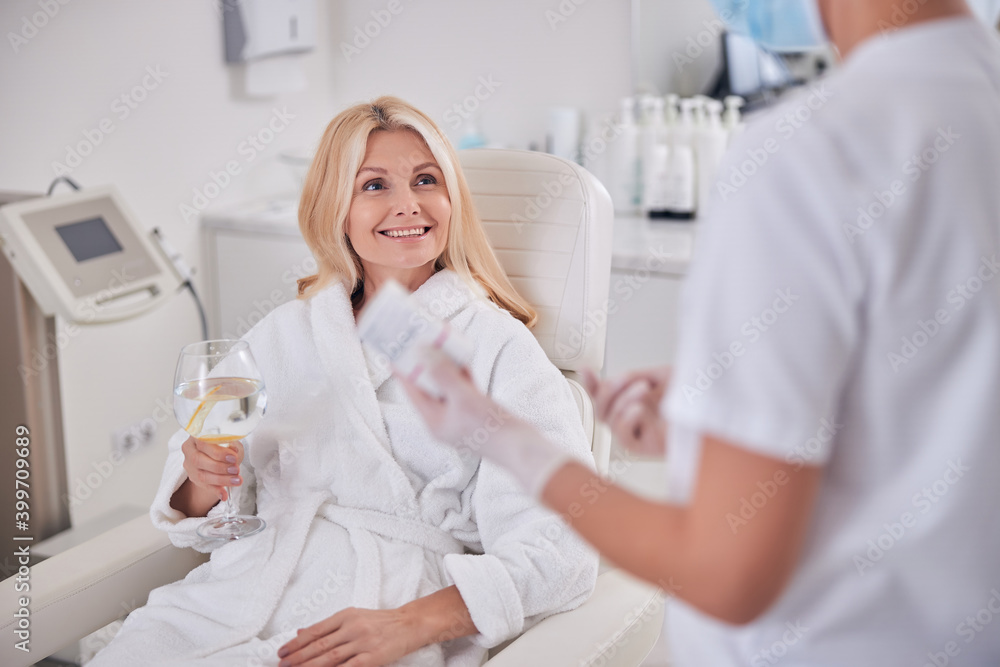 Charming elegant female talking with doctor in specializing cosmetological clinic Charming elegant female talking with doctor in specializing cosmetological clinic
