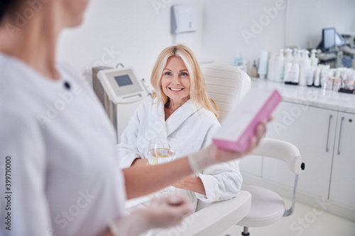 Pretty lady in white clothes looking to her doctor in cabinet