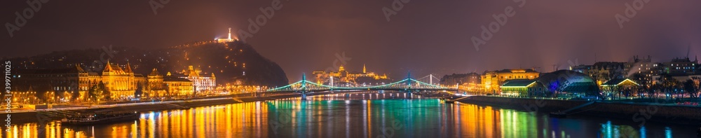 Fototapeta premium Night time skyline panorama of Budapest overlooking Liberty bridge and statue. Hungary