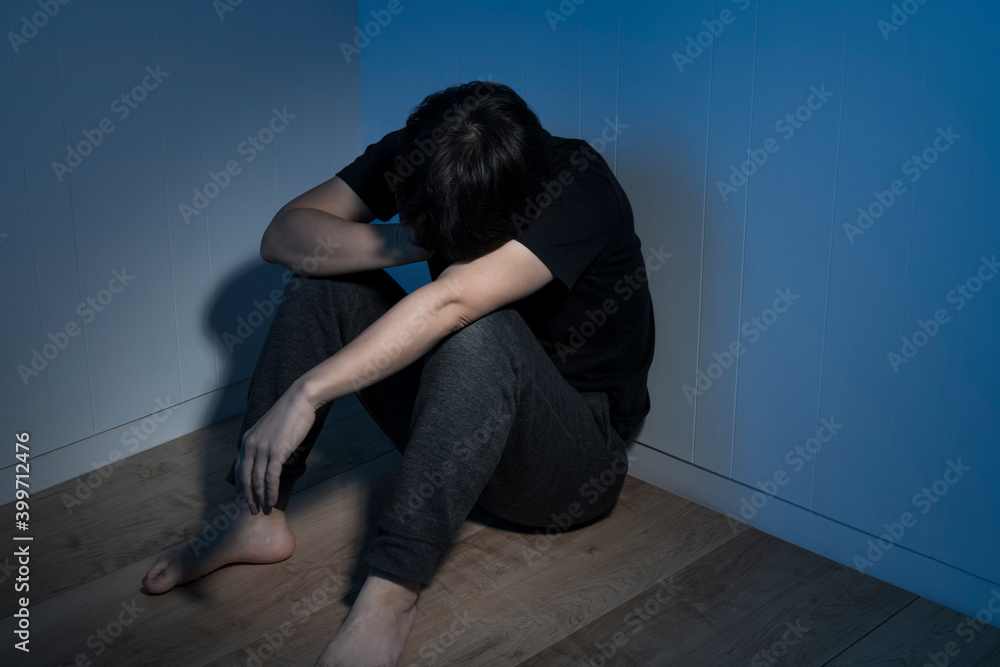 暗い部屋で床に座っている男性 暗い部屋で床に座っている男性