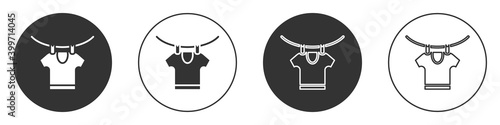 Black Drying clothes icon isolated on white background. Clean shirt. Wash clothes on a rope with clothespins. Clothing care and tidiness. Circle button. Vector.