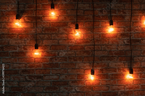 Some lightbulbs are hanging over a brick wall