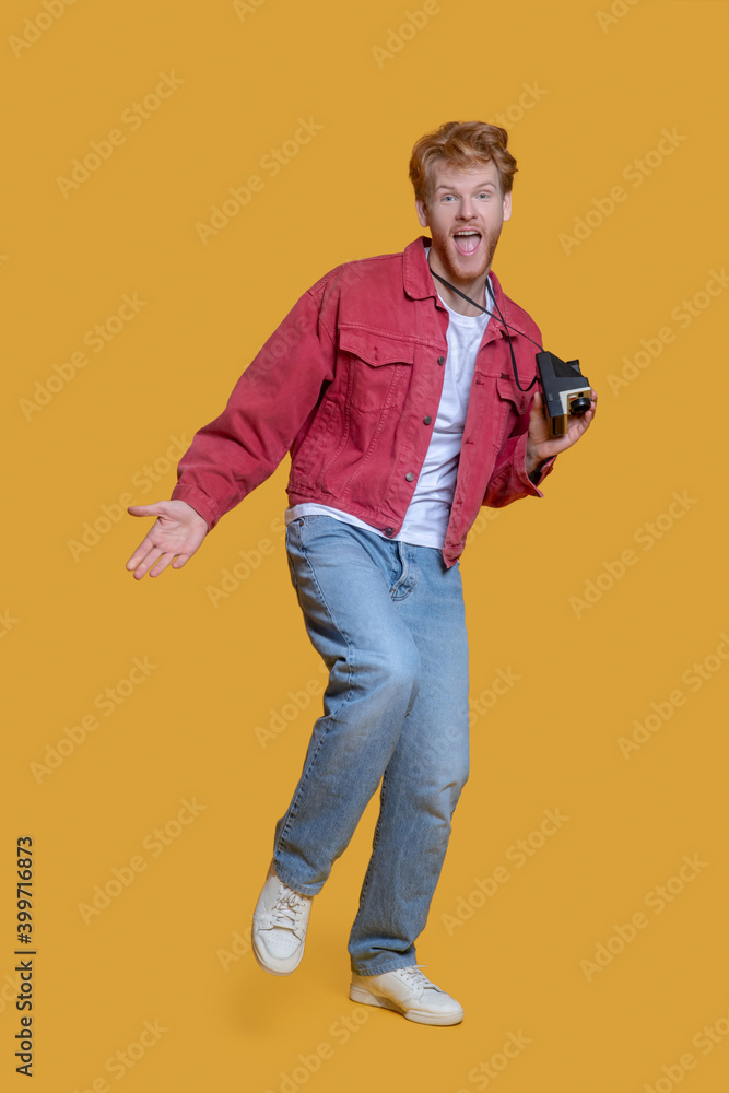 Red-haired bearded young man with old camera feeling awesome Red-haired bearded young man with old camera feeling awesome