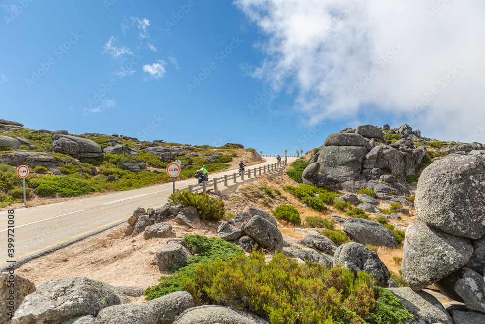 View of road uphill in the Serra da Estrela natural park, with bikers on ride...
