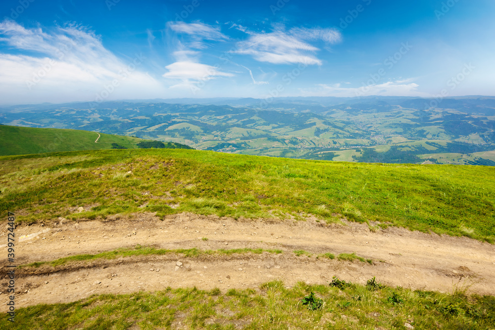 mountain road through grassy meadow. wonderful summer adventure. clouds on the blue sky mountain road through grassy meadow. wonderful summer adventure. clouds on the blue sky