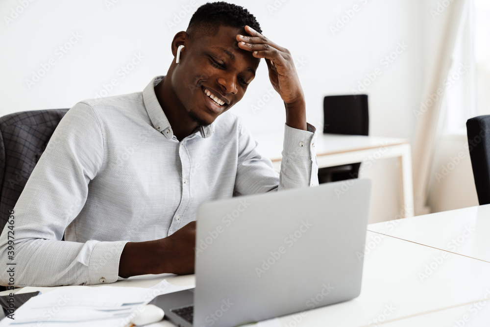 Attractive young dark-skinned businessman in office Attractive young dark-skinned businessman in office