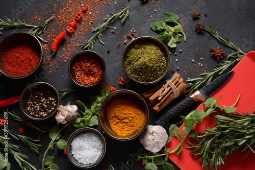 Variety of spices and herbs on kitchen table. Colorful various herbs and spices for cooking on dark background