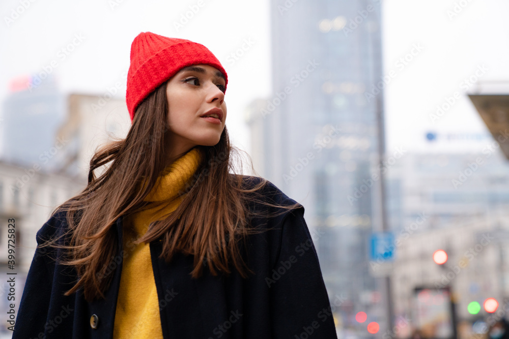 Charming caucasian girl looking aside while posing at city street Charming caucasian girl looking aside while posing at city street