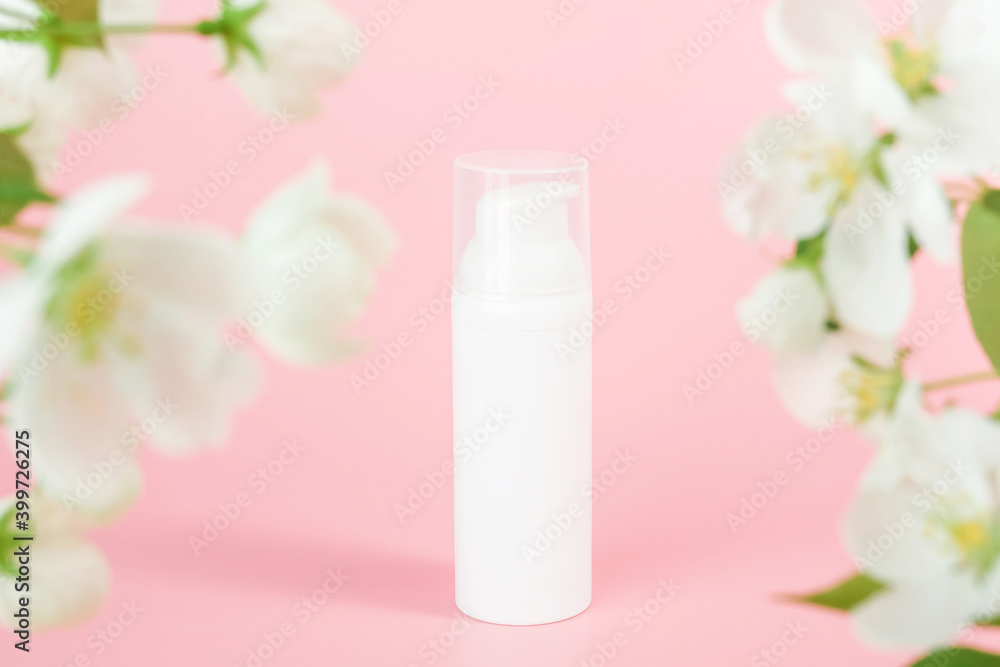 White cosmetic airless dispenser. White blank cosmetics bottles and tube on glass podium and flowering branch, pink background. Natural Organic Spa Cosmetic Beauty Concept Mockup White cosmetic airless dispenser. White blank cosmetics bottles and tube on glass podium and flowering branch, pink background. Natural Organic Spa Cosmetic Beauty Concept Mockup