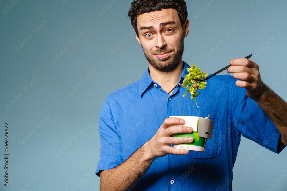 Confused handsome guy eating salad takeaway on camera Confused handsome guy eating salad takeaway on camera