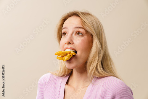 Excited beautiful girl posing with french fries in her mouth