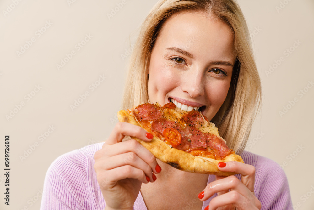 Pleased blonde girl smiling while eating pizza on camera Pleased blonde girl smiling while eating pizza on camera