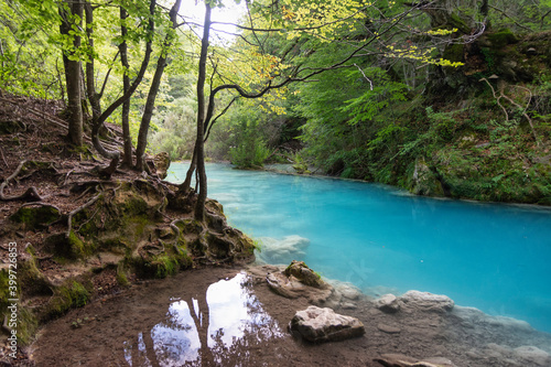 turquoise water river in the forest. There are stones