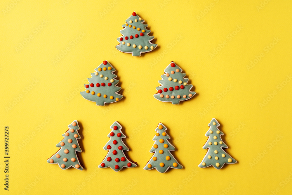 Christmas Gingerbread on yellow background. Fir tree shape, flat lay.