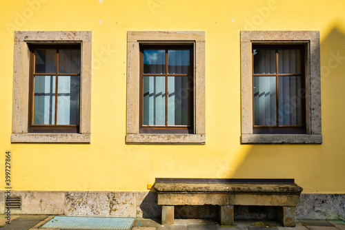 Stone bench near yellow wall © Pawel Pajor