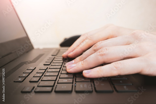 Female hands on the keyboard close-up. The concept of remote work, freelancing, training, online shopping.